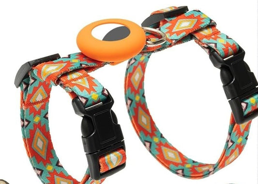 Orange and teal patterned strap harness laid flat: a neck loop and a chest loop with black side-release buckles, a metal ring and a round orange AirTag holder