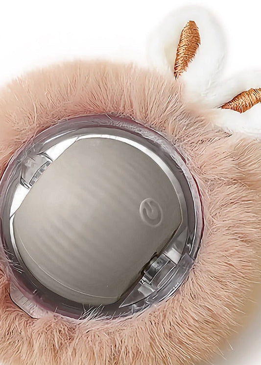 Close-up of a rolling ball held in a fluffy plush cover with two bunny ears, its power button on the front