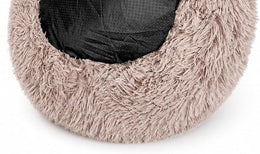 Underside of the beige-brown shaggy donut bed, showing a black base with small dots