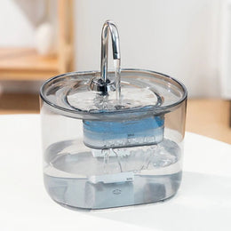 Transparent tap-style cat water fountain showing the water, pump and blue filter inside
