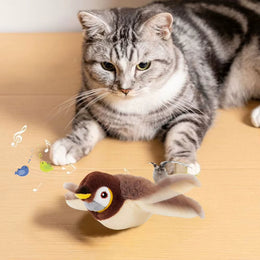 Silver tabby cat lying on a wooden floor behind the plush sparrow toy with its wings spread