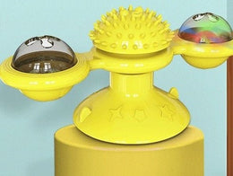 Yellow windmill toy with a spiky centre and two clear domes, one lit up, standing on a yellow block