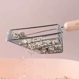 Metal wire litter scoop lifting litter over a pink tray, with loose litter falling through the bars